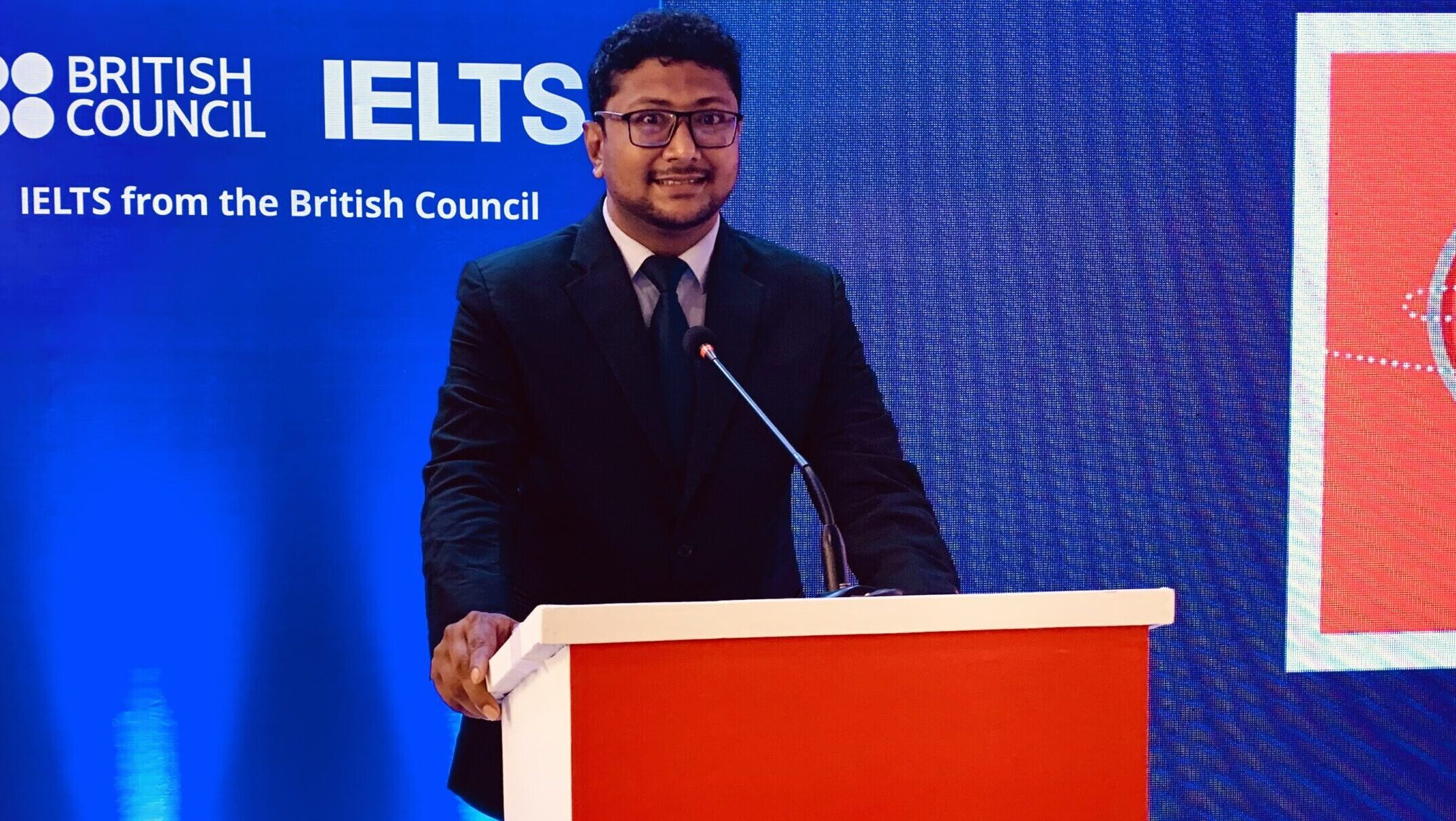 Fahim Sir is on stage, speaking passionately at a British Council event in Bangladesh, with the official British Council logo visible in the background.