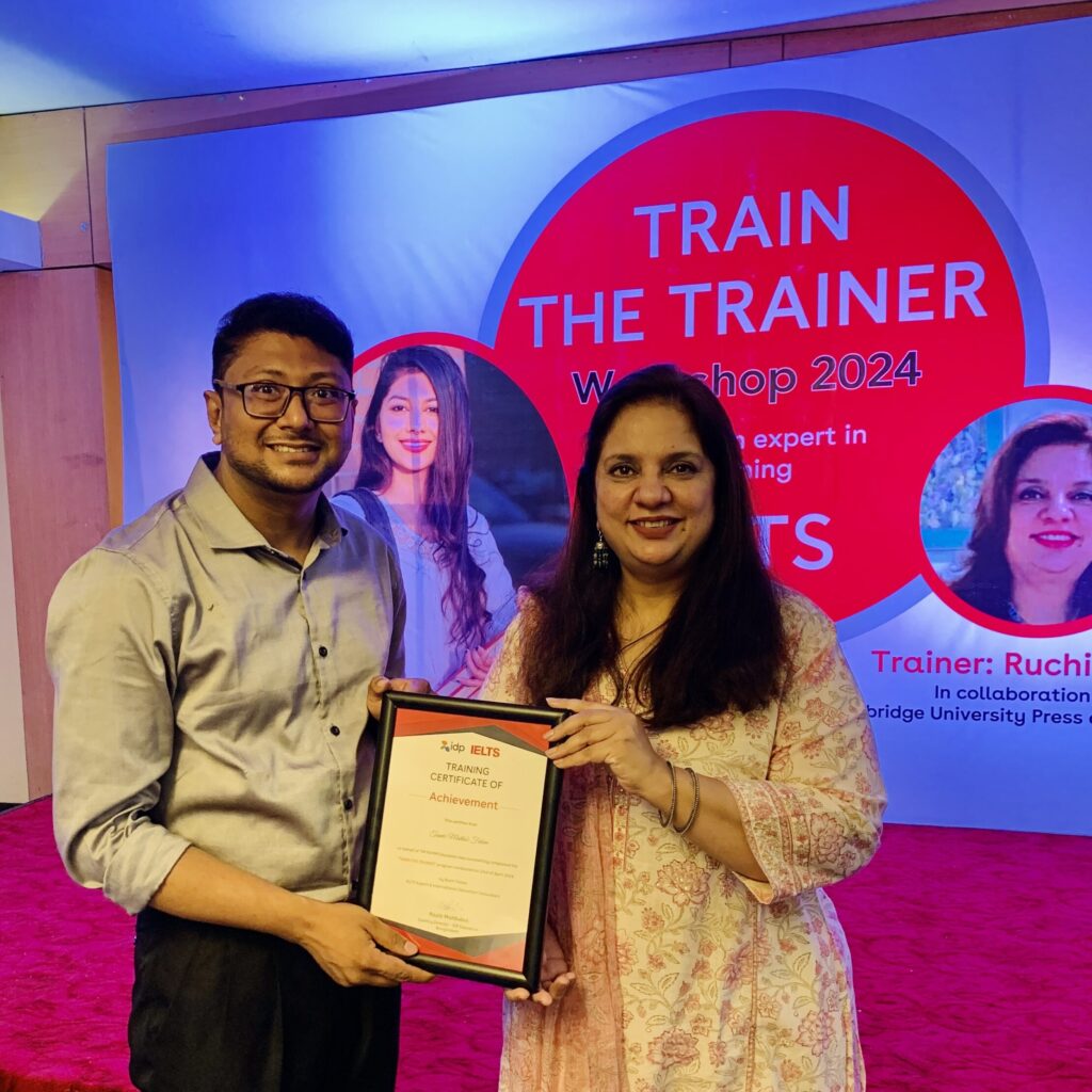 In Kulaura, Sylhet, Bangladesh, Fahim Sir receives a teacher training certificate from Rochi Tomar, a Cambridge certified international trainer, signifying his commitment to delivering quality IELTS instruction, recognized by organizations like IDP.