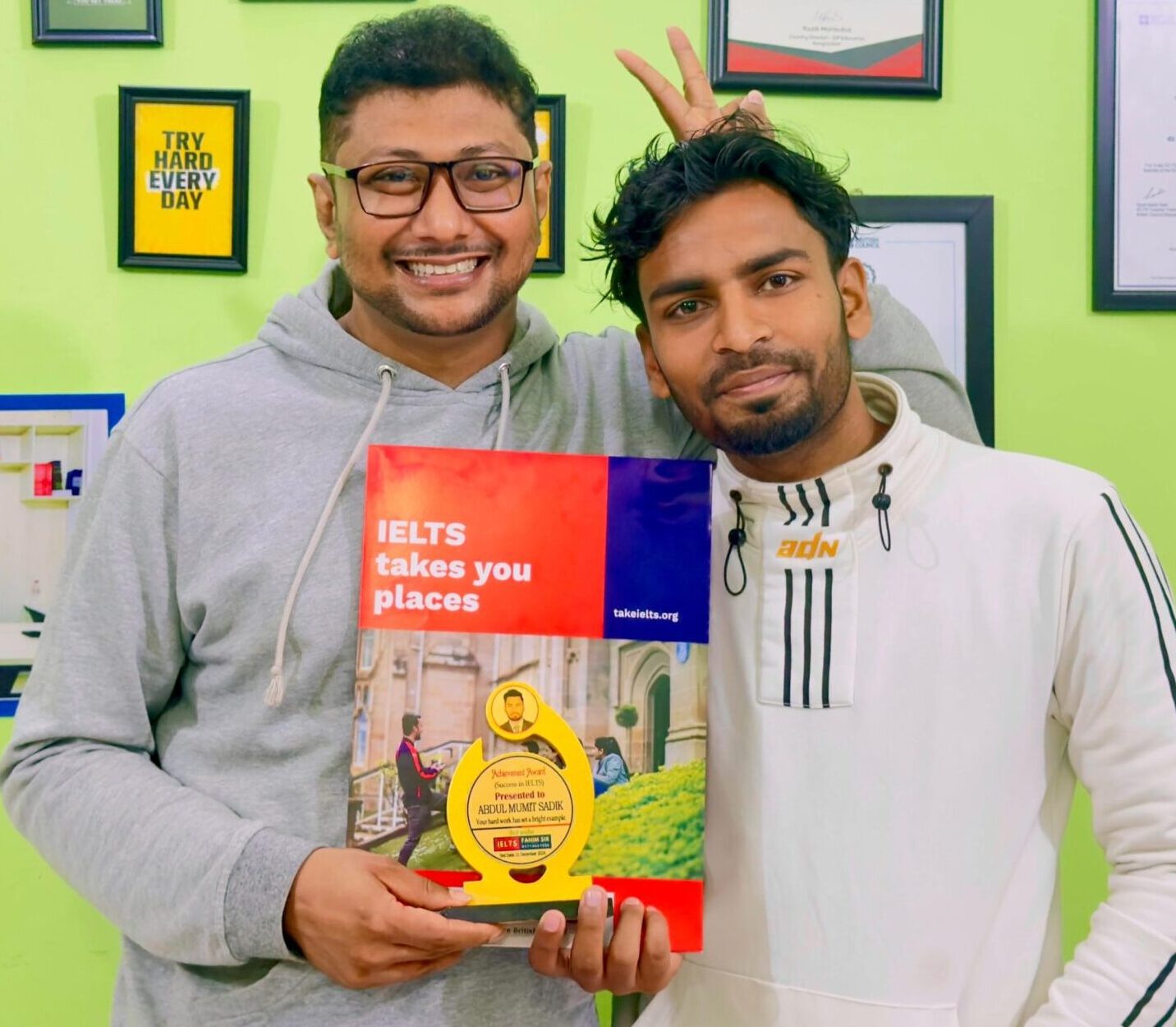 A joyous and proud student, Abdul Mumith Sadik, smiling with his official IELTS score report, celebrating the successful completion of his dedicated study journey.