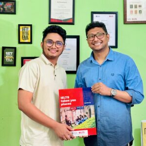 Nazmul Islam Fahad standing with Fahim Sir, holding his IELTS TRF as a symbol of exam success and academic achievement.
