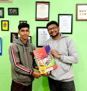 Biprojit Dey celebrating his IELTS success, with a happy expression and holding his official test result.
