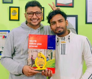 A joyous and proud student, Abdul Mumith Sadik, smiling with his official IELTS score report, celebrating the successful completion of his dedicated study journey.